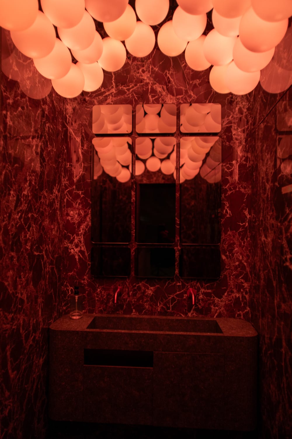 Globe lights above red marble.