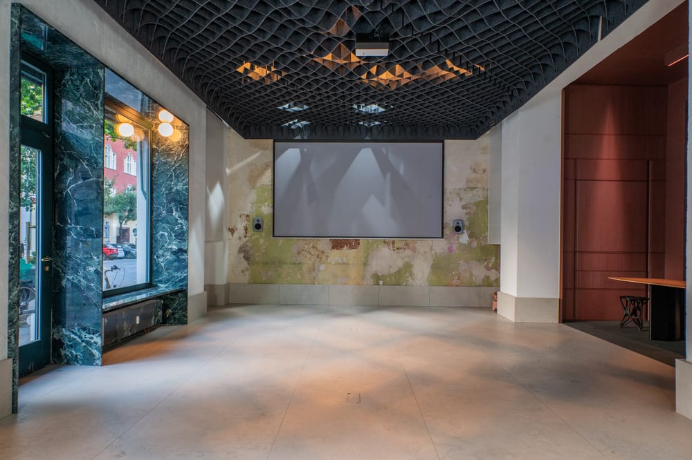 The screen in the hall, open floor in front of it, daylight from the side.